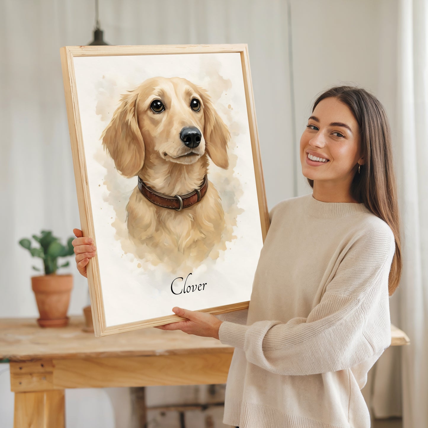 Woman holding a framed portrait of a dog named 'Clover' in a home setting.